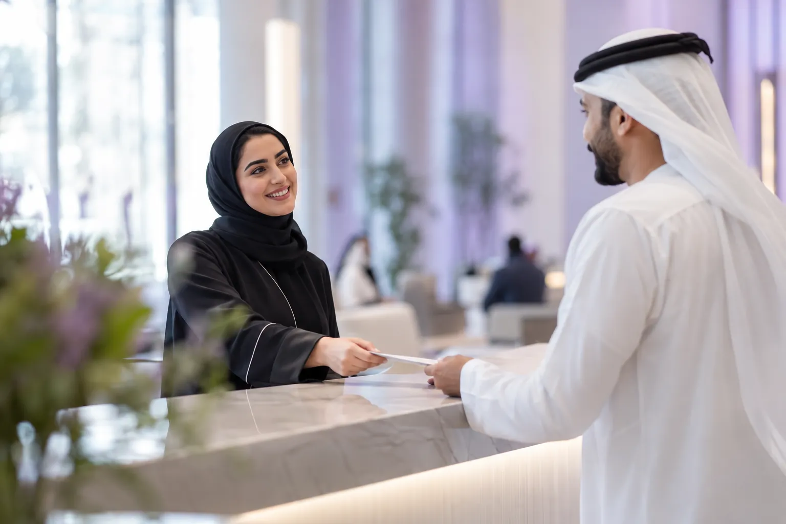 A customer happiness centre officer greeting a visitor across the counter in a bright service hall
