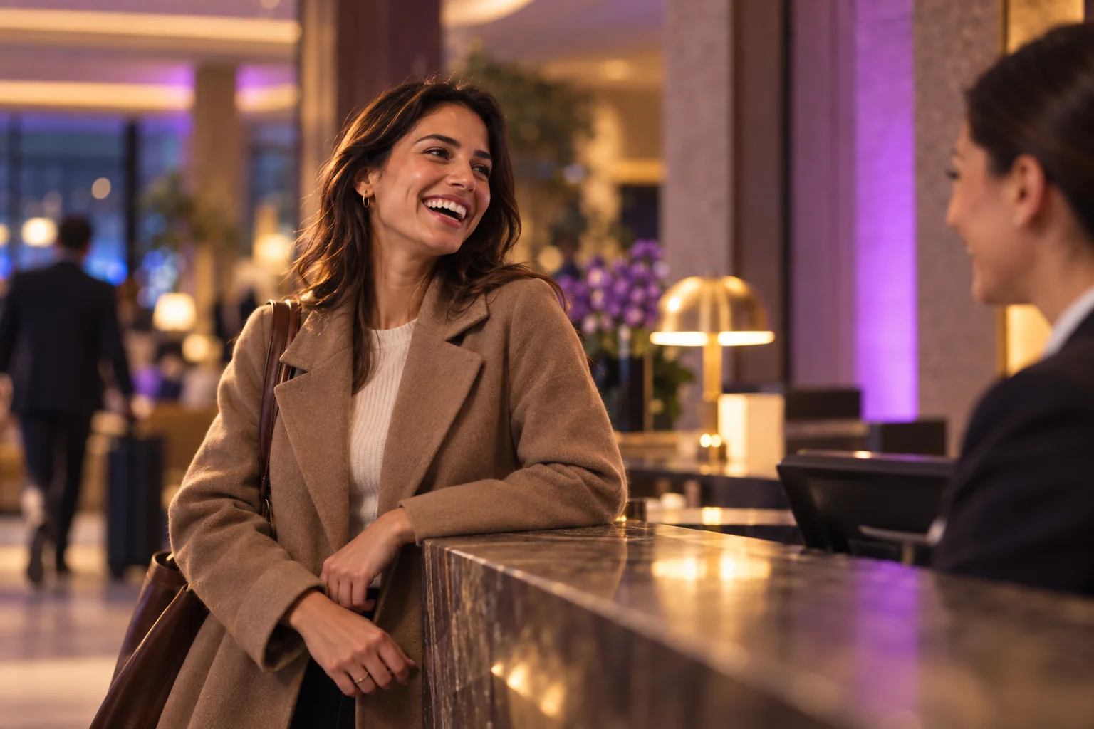 Hotelgast lacht beim Check-in mit der Rezeptionistin